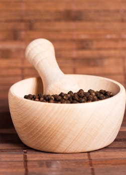 Peppercorns in a wooden mortar