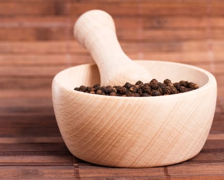 Peppercorns in a wooden mortar