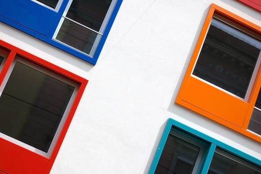 Detail of a white house with multi colored windows