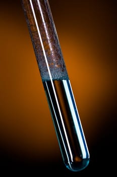 Glass test tube filled with liquid and foam