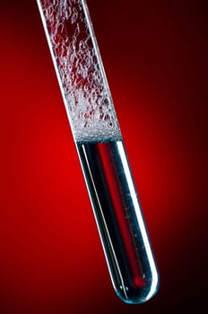 Glass test tube filled with liquid and foam