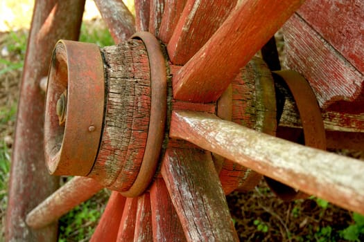A Old weathered red wagon wheel