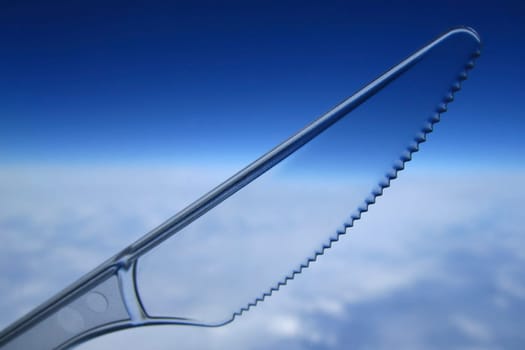 Clear plastic disposable knife against the sky