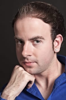 Portrait of a pensive young handsome man touching his chin
