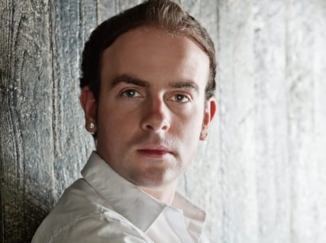 Portrait of serious young handsome man with earrings