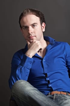 Portrait of a pensive young handsome man touching his chin