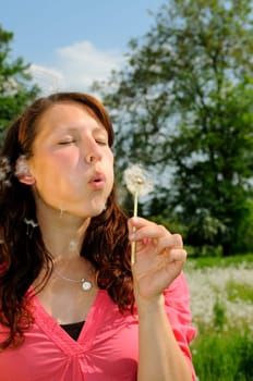 Young woman with dandelion