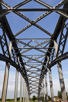 Old iron railway bridge with blue sky background