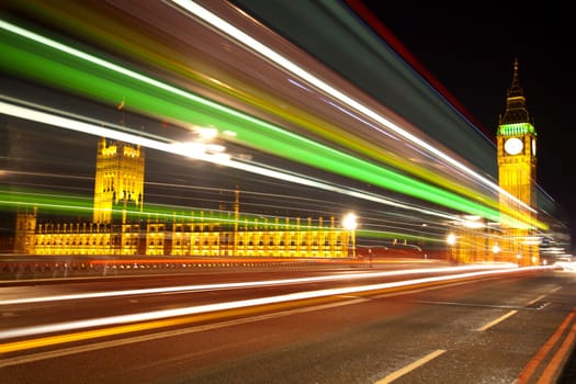 Big Ben and Houses of Parliament in London with lights effect from incoming bus