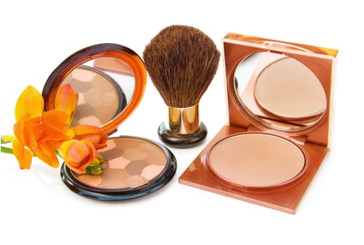Luxury makeups bronzers with brush and Freesia flower. Isolated on white background.