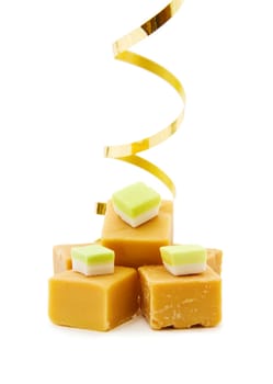 Joy of food - caramel fudge with golden ribbon. Isolated on white background.