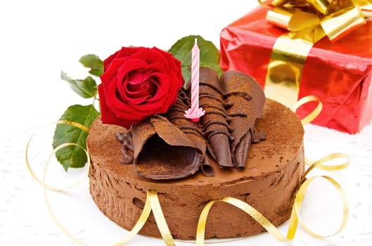Celebrating birthdays with delicious toffee cake, red rose and gifts. Isolated on white background.