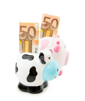 Fight the economic crisis by saving money with Cowie and Piggy banks. Isolated over white background.
