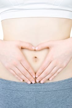 Woman showing heart shape with her hands on stomach