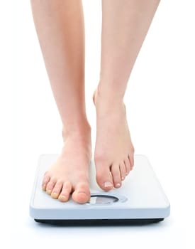 Bare female feet standing on bathroom scale