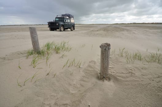beach of St. Peter Ording at the german Atlantic coast with four wheel drive expedition vehicle