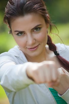 young fitness woman doing punching exercises outdoors