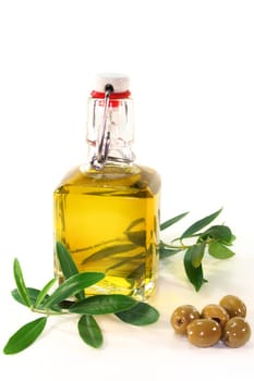 a bottle of olive oil with olive branch and olives