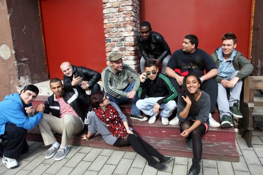 Ten young people sit together and have fun.  The group consists of boys and girls.