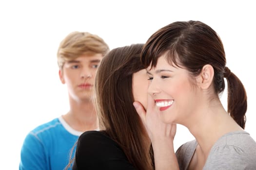 Two girls talking (gossip) about boy, isolated on white