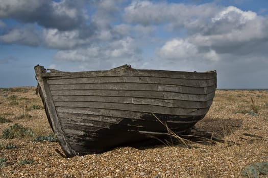 Rundown old fishing boat marooned on a beach