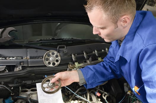 The master craftsman explains to the trainee the work on the engine compartment in the car workshop