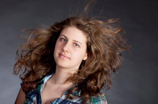 young brunette woman with long flying hair, studio shot