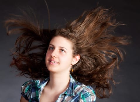 young brunette woman with long flying hair, studio shot