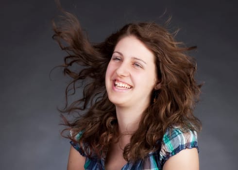 young brunette woman with long flying hair, studio shot
