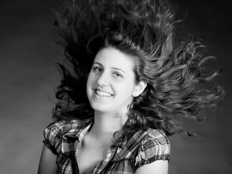 young brunette woman with long flying hair, studio shot