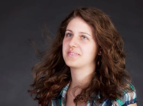young brunette woman with long flying hair, studio shot