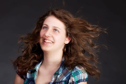 young brunette woman with long flying hair, studio shot