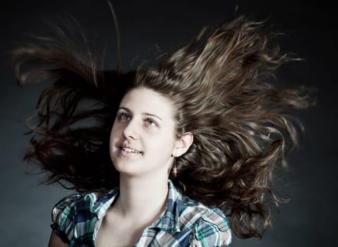 young brunette woman with long flying hair, studio shot