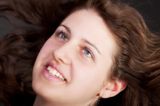 young brunette woman with long flying hair, studio shot