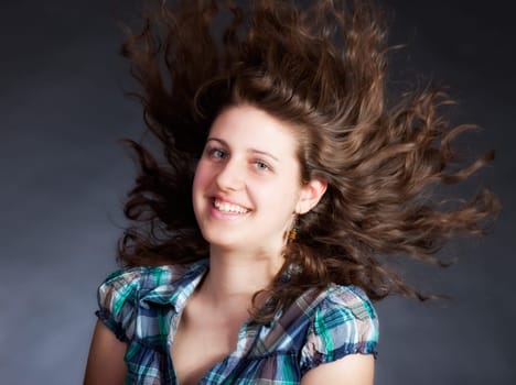 young brunette woman with long flying hair, studio shot