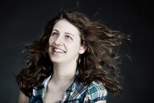 young brunette woman with long flying hair, studio shot
