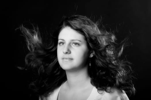 young brunette woman with long flying hair, studio shot