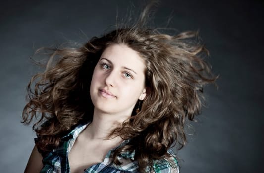 young brunette woman with long flying hair, studio shot