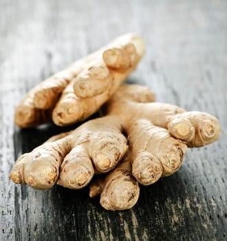 Close up of fresh ginger root spice on wooden table