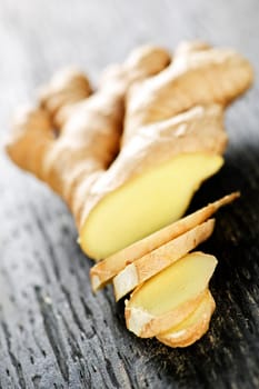 Close up of sliced fresh ginger root spice on wooden table