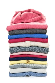 Stack of warm sweaters isolated on white background