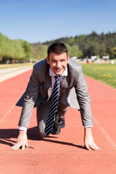 young businessman on a running track in summer