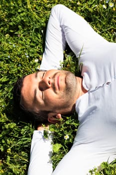 young man sleeping on the grass in summer
