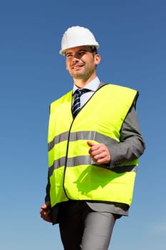 young businessman with hardhat and blue sky