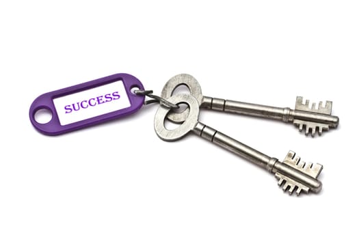Key with a success tag closeup on white background