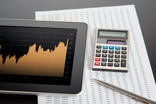 Modern stock market analyze with digital tablet, calculator, pen and printed data sheet