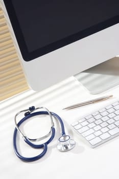 General practitioner (doctor) workplace with computer and stethoscope