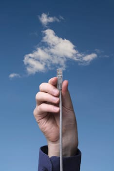 Cloud computing concept. Hand with ethernet cable connecting into cloud.