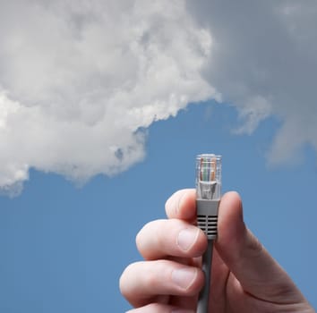 Cloud computing concept. Hand with ethernet cable connecting into cloud.