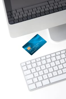 Credit card on white desk with computer - electronic payment concept. I am author of image used on credit card and used data are fictitious.
